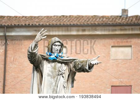 Ferrara, Italy - June, 30, 2017: monument of Girolamo Savonarola in Ferrara, Italy with the blue scarf for fun tied to it