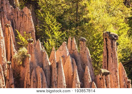  Renon's earth pillars at sunrise. Journey to  magical fairy-tale country. Magnificent Tyrol in the Dolomites. The concept of ecological and ethnographic tourism 