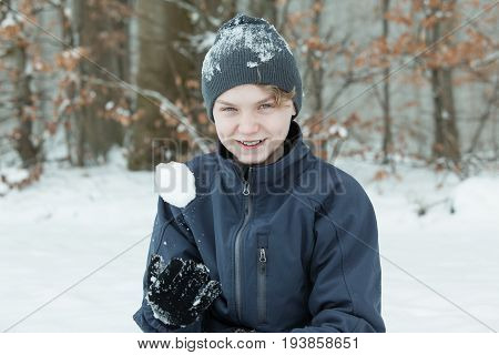 Boy Playing With Snowball Outside