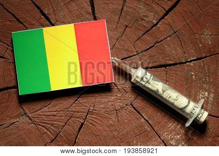 Malian Flag On A Stump With Syringe Injecting Money In Flag