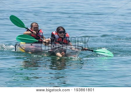 Labuan,Malaysia-May 1,2017:Group of tourist enjoying a weekend kayaking with the transparent kayak in Rusukan Besar island,Labuan,Malaysia.Labuan is the ideal place for water sports,like kayaking & scuba diving