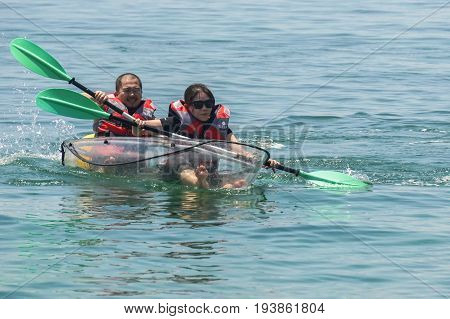 Labuan,Malaysia-May 1,2017:Group of tourist enjoying a weekend kayaking with the transparent kayak in Rusukan Besar island,Labuan,Malaysia.Labuan is the ideal place for water sports,like kayaking & scuba diving