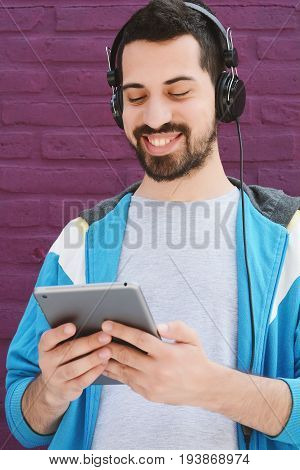 Young latin man using a tablet. Uraban scene