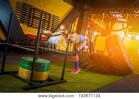 Beautiful girl pushes weight in a gym