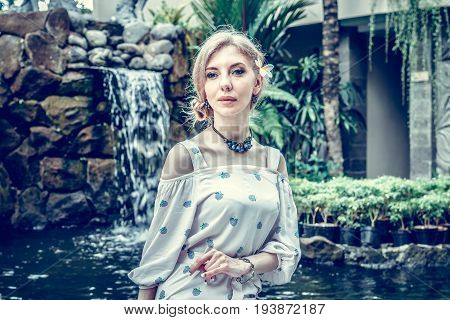 Woman is posing in a tropical garden of Bali island.