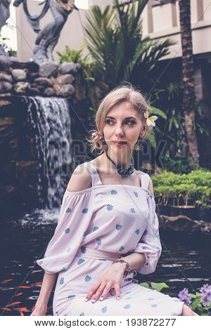 Woman is posing in a tropical garden of Bali island.