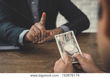 Businessman refusing money Japanese yen bills - anti bribery and corruption concepts