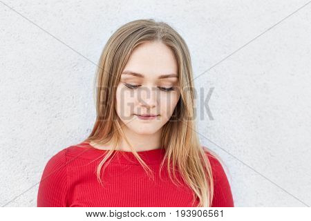 Adorable Blonde Woman In Red Dress Looking Thoughtfully Down Thinking Over Her Relationships With Bo