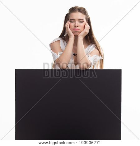 Young jocose woman portrait of a confident businesswoman showing presentation, pointing placard black background. Ideal for banners, registration forms, presentation, landings, presenting concept..