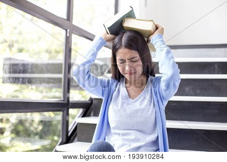 Young Asian Woman Feeling Stress When Reading A Book For Final Exam 1 Person.
