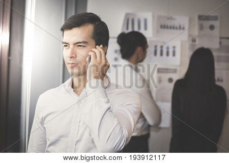 Businessman Using Smartphone And Looking To The Other Place Vintage Tone.