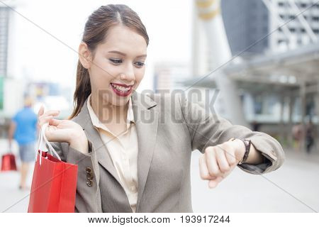 Young Asian Businesswoman Looking To Wacth With Attractive Smiling At City. Woman Working At City Co
