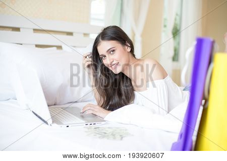 Beautiful Young Woman Using Laptop For Shopping On The Bed Woman With Online Shopping Concept.