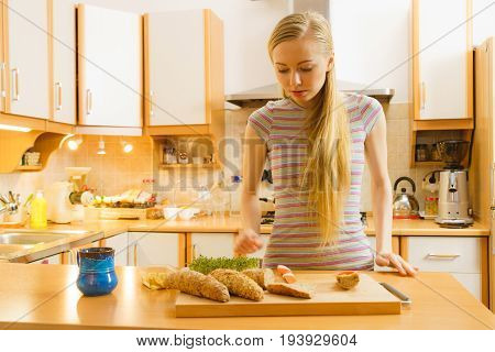 Woman In Kitchen Holding Knife Making Healthy Sandwich
