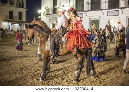 El Rocio Spain - June 4 2017: Group of pilgrims on horseback in traditional spanish dress in El Rocio during the Romeria 2017. Province of Huelva Almonte Andalusia Spain