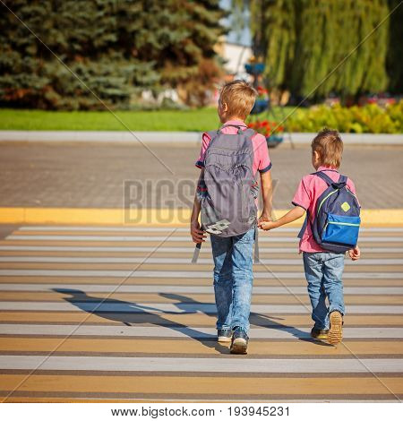 Two Boys With Backpack Walking, Holding On Warm Day On The Road.