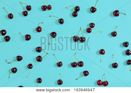 Fresh juicy cherries on mint background, top view. Copy space. Still life mockup flat lay