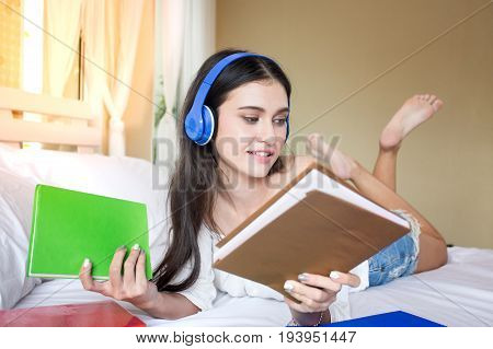 Beautiful Young Woman Looking And Holding Book On The Bed, Woman Education Concept, 20-30 Year Old.
