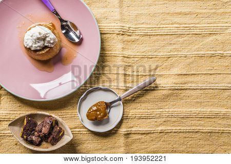 Flan - A Sweet Custard Creme Caramel With Creme On Top, On A Pink Plate Over A Wooden Board.