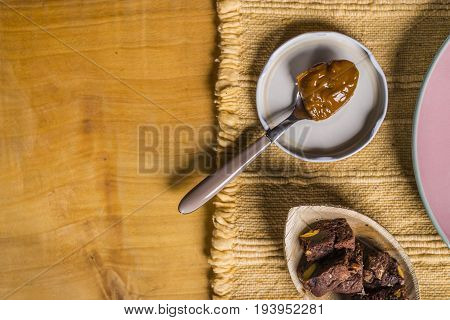 Flan - A Sweet Custard Creme Caramel With Creme On Top, On A Pink Plate Over A Wooden Board.