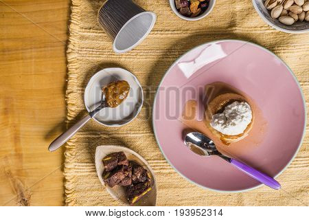 Flan - A Sweet Custard Creme Caramel With Creme On Top, On A Pink Plate Over A Wooden Board.