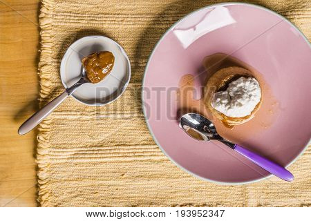 Flan - A Sweet Custard Creme Caramel With Creme On Top, On A Pink Plate Over A Wooden Board.