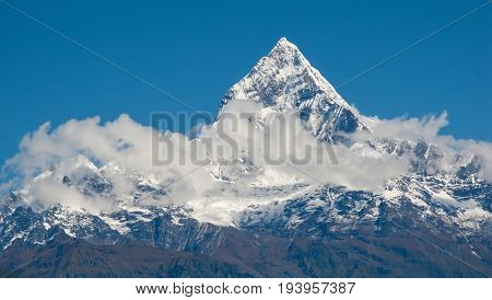 POKHARA, NEPAL. Shooting from a bird's eye view from a deltaplan. The Himalayas, Machapuchare (Fishtail) on the background of blue sky.