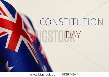 some Australian flags and the text Constitution Day written in blue and red against an off-white background