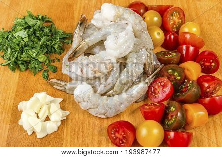 Seafood. Ingridients for spaghetti pasta with prawns or shrimps with mixed colours cherry tomatoes fresh parsley