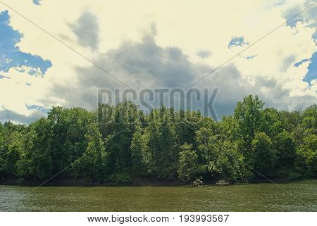 Cloud over the river and wooded shore.