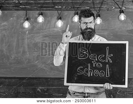 Back To School Concept. Man With Beard And Mustache On Strict Face Warns Students, Chalkboard On Bac