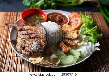 Fried pomfret fish and rice, popular traditional Malay or Indonesian local food.