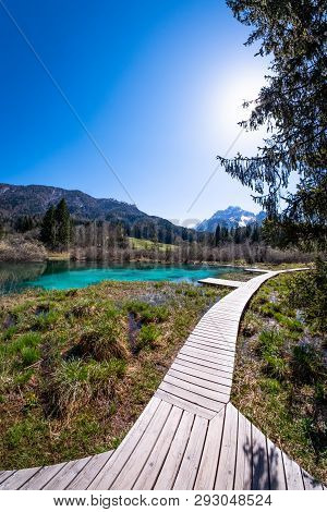 Lake Zelenci, Source Of The Sava Dolinka River, With The Observation Trail Footbridge And Ponce Moun