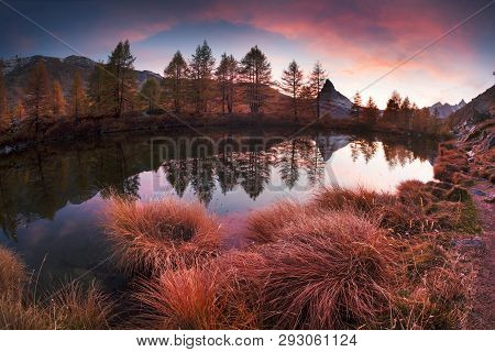 Autumn Larches On The Background Of The Matterhorn And Autumn In The Alps. The Clear Water Of The Mo