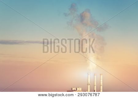 Three Smoking Stack Pipes Making Clouds Of White Smoke With Dramatic Sunset Sky Background. Industri