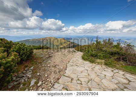 Hiking trail from Babia Gora Mountain to Przelecz Brona Pass in Polish Beskid. High mountains landscape under blue sky with clouds.
