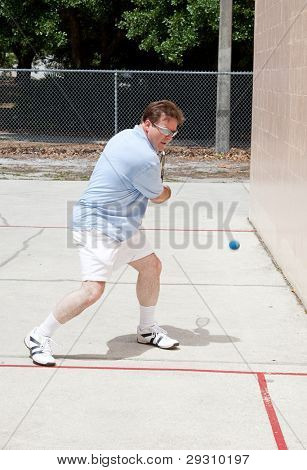 Střední dospělý muž, divoký zahrát squash.