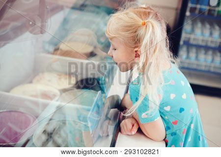 Caucasian Funny Blonde Child Girl Looking At Ice Cream In Shop Window Trying To Choose One. Kid With