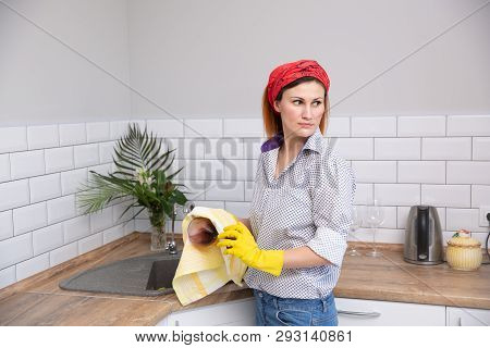 Woman Cleaning Or Ruges Glass In The Kitchen.