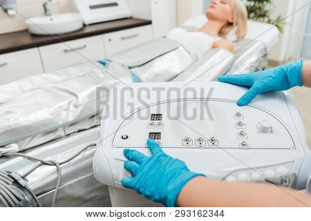 Cropped View Of Cosmetologist Setting Up Machine For Pressotherapy