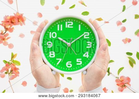 Female Hands Holding Vintage Alarm Clock Flat Lay With Colorful Springtime Floral Decoration Of Peta
