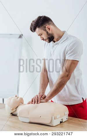 Handsome Man Using Chest Compression Technique On Dummy During Cpr Training