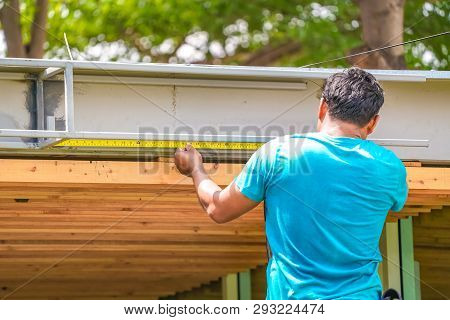 Asian Worker Measure The Steel Waterdrain Structure Of The Roof Top For Home Improvement And Develop
