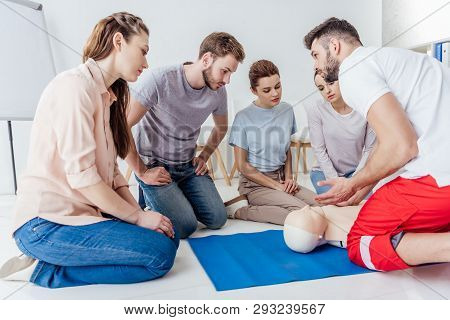 Instructor Gesturing During First Aid Training With Group Of People