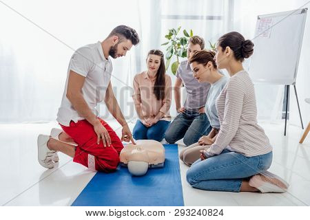 Instructor Gesturing During First Aid Training With Group Of People