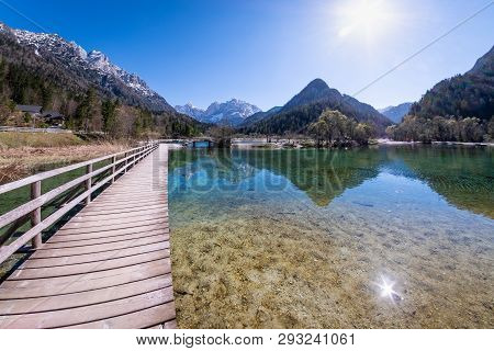 Bridge Over Lake Jasna With Mountains Razor And Prisojnik On The Horizont In Slovenia