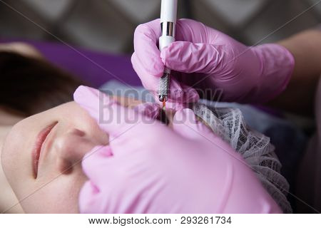Permanent Makeup For Eyebrows. Microblading Brow. Beautician Doing Eyebrow Tattooing For Female Face