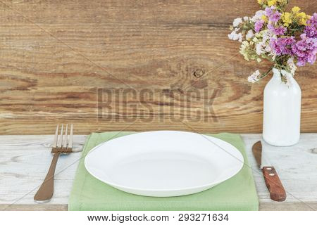 Empty Plate On Tablecloth Or Napkin On Wooden Table Over Wooden Background. Table Setting.