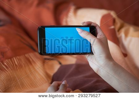 Saint-Petersburg / Russian Federation - 27 March 2019: Female hand with manicure holding cellphone with VK