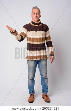 Full Body Shot Of Handsome Persian Man Showing Something Ready For Winter